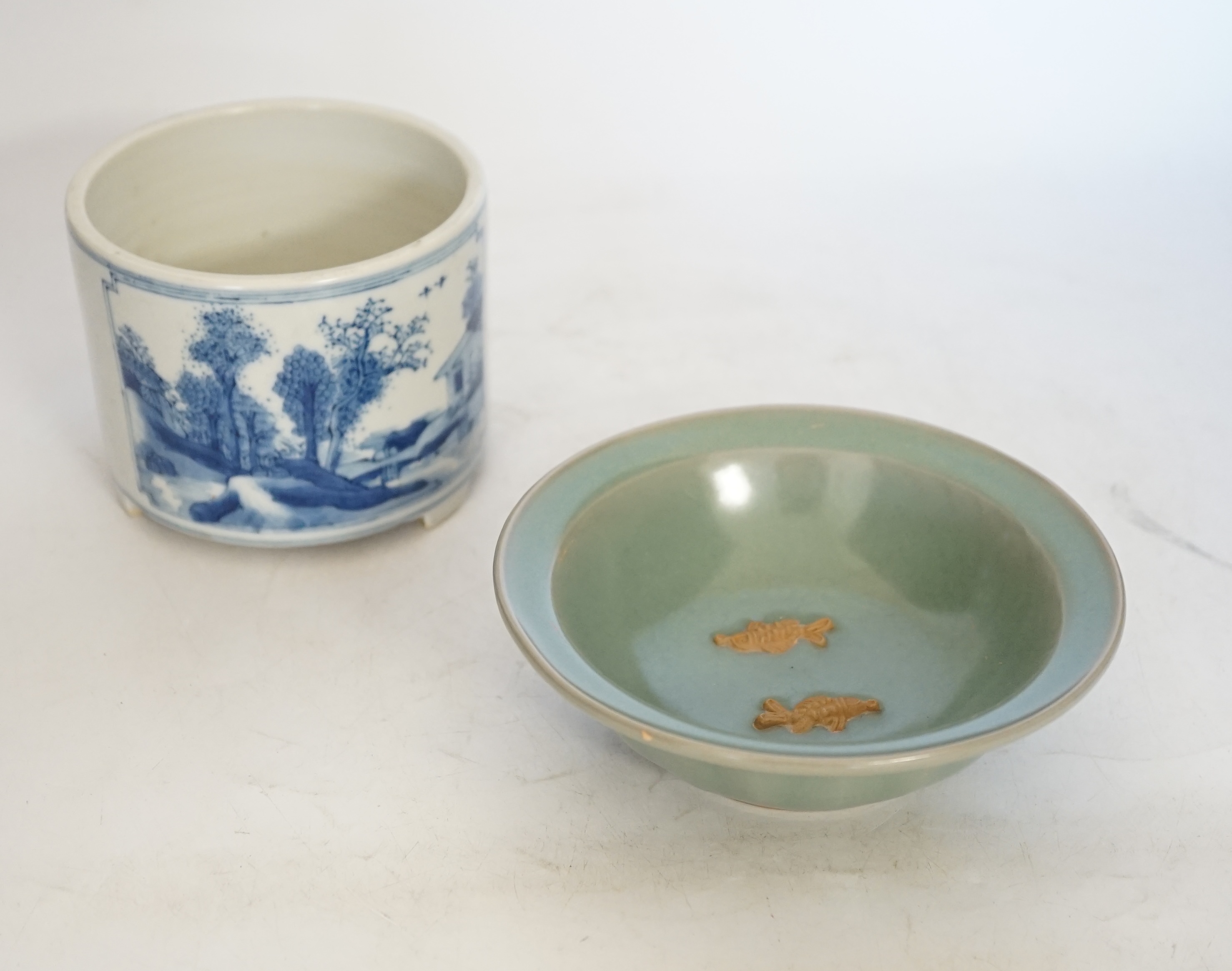 A Chinese blue and white footed brushpot and celadon glazed ‘fish’ bowl, tallest 9cm. Condition - good